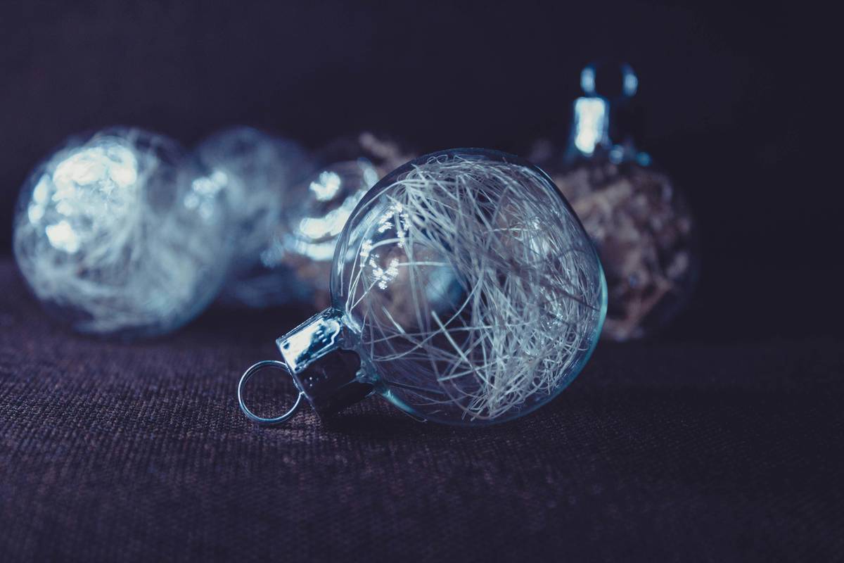 Side-by-side comparison: authentic hand-blown mercury glass bauble (left) vs. mass-produced plastic imitation (right). Authentic shows subtle clouding and depth; fake appears flat and overly shiny.
