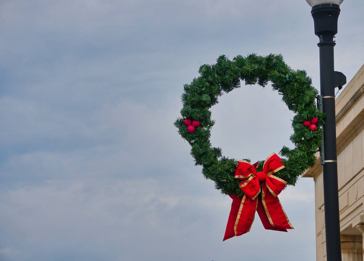 Side-by-side comparison: tangled DIY light strings vs. clean, even glow of a quality pre lit wreath on a front door