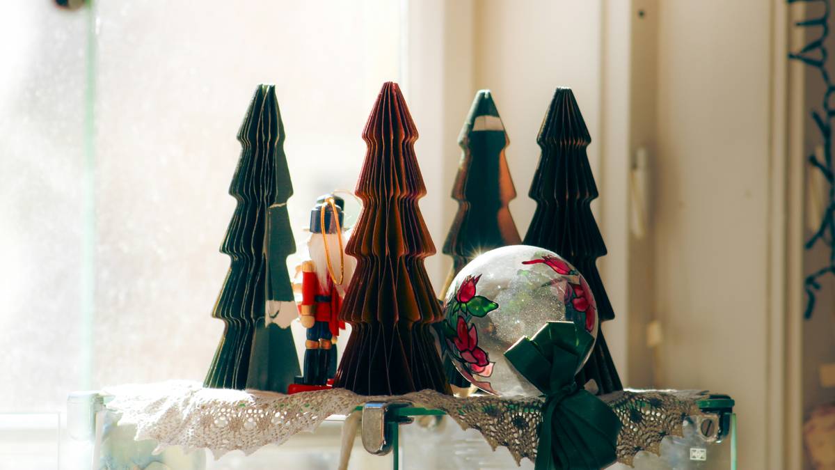 Side-by-side comparison: tree with plastic angel vs. same tree with emerald velvet bow topper showing improved cohesion with room decor