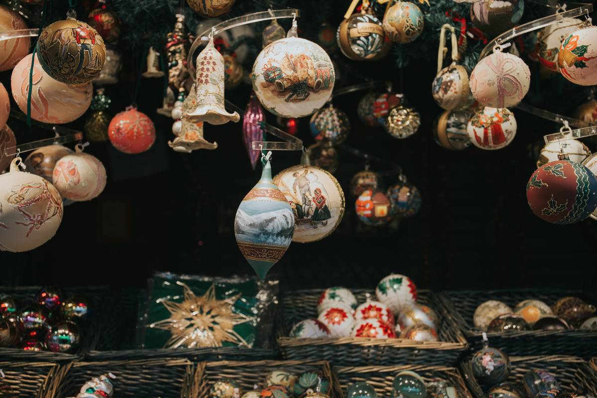 Side-by-side photo: left shows mass-produced plastic ornaments from big-box store; right displays curated thrifted glass ornaments with patina and unique details